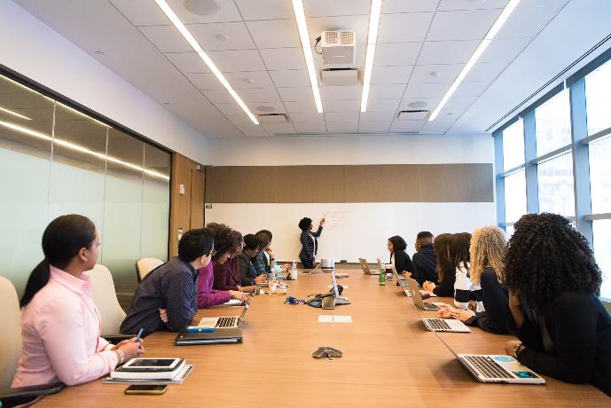 les gens sur la table de conférence regardant la femme qui parle